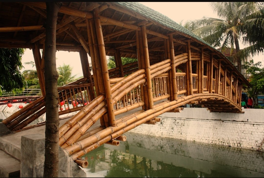 Puente techado de bambú sobre un canal